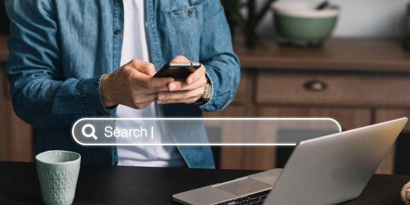 A person using a smartphone with a search bar overlay, representing keyword research for SEO and content optimization.