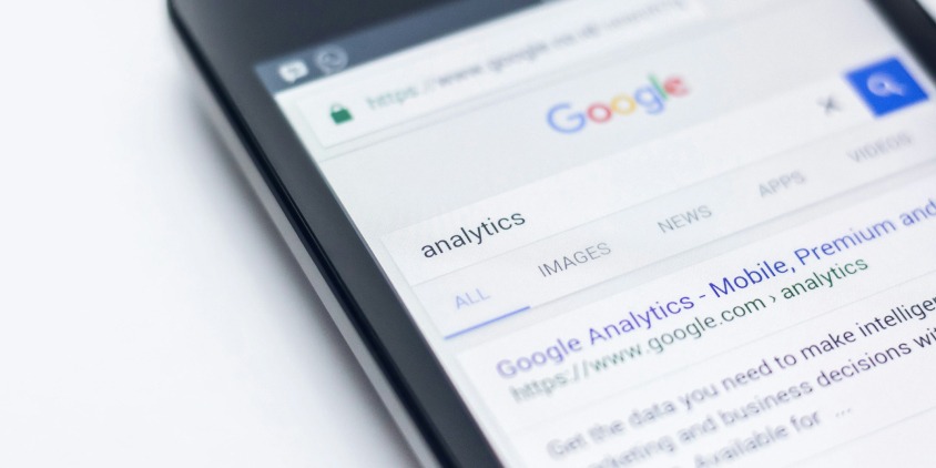 A smartphone displaying a Google search result for analytics, symbolizing strategies for optimizing local SEO.