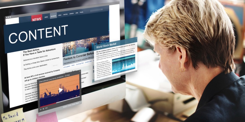 A professional working on a desktop computer displaying content examples, representing content creation and optimization strategies for better website performance.